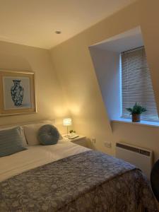 Un dormitorio con una cama grande y una ventana en The Riding Gate Apartment en Kent