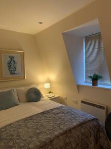 Un dormitorio con una cama grande y una ventana. en The Riding Gate Apartment, en Kent
