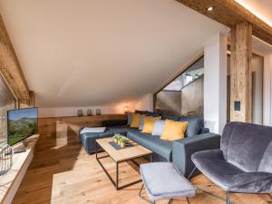 a living room with a blue couch and a tv at Haus Prem in Hopfgarten im Brixental