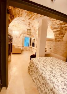 una camera con un letto in una stanza con un muro in pietra di Vermaaten Boutique Suites Ruby a Todi