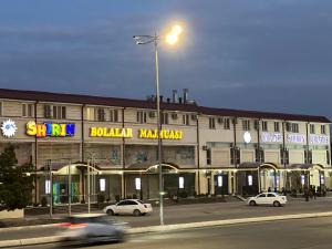 un edificio con coches estacionados frente a él en Grand Shirin Palace Bux en Bukhara