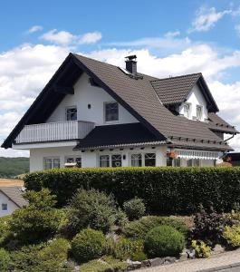 a large white house with a black roof at Ferientraum-am-Rothaarsteig in Wilnsdorf