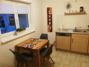 a kitchen with a table and chairs and a sink at Ferientraum-am-Rothaarsteig in Wilnsdorf