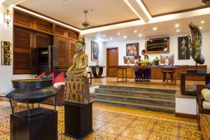 een woonkamer met een standbeeld in het midden bij Montra Nivesha residence and Art in Siem Reap