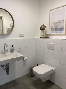 een badkamer met een toilet, een wastafel en een spiegel bij Fachwerk Hotel Wuppertal in Wuppertal