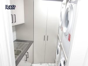 a kitchen with a sink and a washing machine at Kunda House Croydon in Birmingham