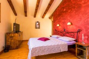 a bedroom with a bed with a red wall at Villa Mala Kopa in Barban +32 photos