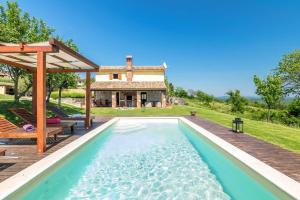 an outdoor pool with a gazebo and a house at Villa Mala Kopa in Barban