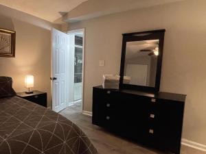 a bedroom with a black dresser and a mirror at Suite 4 - Private Apartment Historical Home in Macon