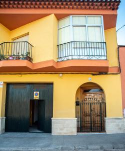 un edificio giallo con balcone e due porte di APARTAMENTOS SAN ANTON a Villarrobledo