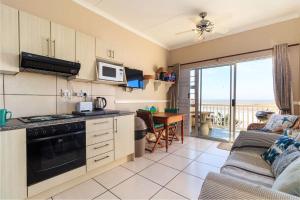 a kitchen with a couch and a stove top oven at Unit 18 Kei Sands Resort in Kei-mouth Village