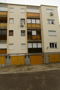 um edifício de apartamentos com portas laranja ao lado de uma rua em Kovács apartman Harkány em Harkány