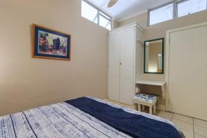 a bedroom with a bed and a sink and a mirror at Unit 18 Kei Sands Resort in Kei-mouth Village