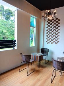 uma sala de jantar com uma mesa e cadeiras e uma janela em Sleepbox Hotel em Cameron Highlands