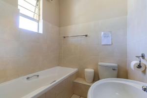 Unit 18 Kei Sands Resort في Kei Mouth: حمام مع حوض ومرحاض ومغسلة