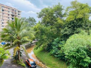 an orange car parked next to a palm tree at BATU FERRINGHI BAYU EMAS APARTMENT in Batu Ferringhi