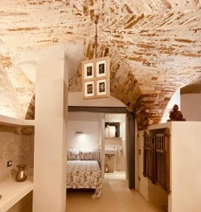 1 dormitorio con 1 cama en una habitación con techo de piedra en Vermaaten Boutique Suites Ruby, en Todi