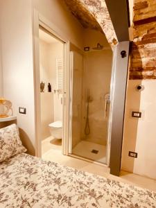 a bedroom with a shower and a bed in a room at Vermaaten Boutique Suites Ruby in Todi