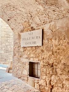 un cartello sul lato di un muro di pietra di Vermaaten Boutique Suites Ruby a Todi