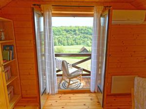 um quarto com uma porta que abre para uma varanda com uma cadeira em Lavanda Land - Villa Tanya Mrežnica em Donji Zvečaj