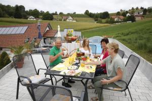 eine Gruppe von Menschen, die auf einer Terrasse am Tisch sitzen in der Unterkunft Sonnenwiese in Unterlamm 58 in Unterlamm