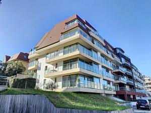 un gran edificio de apartamentos con techo marrón en Residentie Laurence - 'SEAGIRL' en Oostduinkerke