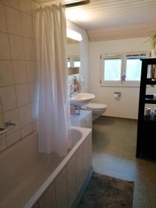La salle de bains est pourvue de 2 lavabos, d'une baignoire et de toilettes. dans l'établissement Schwellbrunn,Ferienwohnung mit Säntissicht, à Schwellbrunn