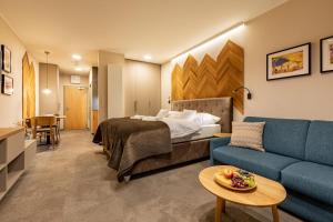 Habitación de hotel con cama y sofá en APLEND Lake Resort, en Štrbské Pleso