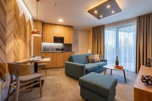 a living room with a couch and a table at APLEND Lake Resort in Vysoke Tatry - Strbske Pleso