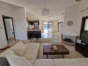 uma sala de estar com um sofá branco e uma mesa em The Belvedere Villa Latchi em Lachi