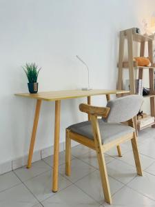 a wooden table with a chair and a desk at Chenang's Guest House by The Nordic House in Pantai Cenang