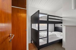 a bedroom with a bunk bed and a door at Sct Knudsborg - 12J - Summerhouse on the beach in Brenderup