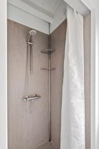 eine Dusche im Bad mit Vorhang in der Unterkunft Remarkable 2-Bed Beach House 12J in Brenderup