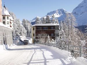 a building on a snow covered street with a mountain at Miraflor Rosita - Arosa Holiday in Arosa