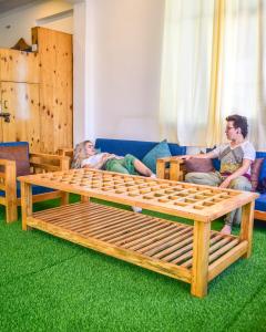 a group of people sitting on a couch with a wooden bed at Skyard Premium, Tapovan in Rishīkesh