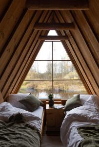 - 2 lits dans une chambre avec une grande fenêtre dans l'établissement Jõemaja, à Oiu