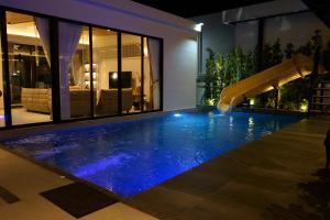 una piscina con scivolo in una casa di Movenpick Pool villa by Angkana a Na Jomtien