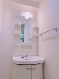 a white bathroom with a sink and a mirror at Picoro Hakata - Vacation STAY 11328 in Fukuoka