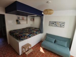 1 dormitorio pequeño con 1 cama y 1 sofá en Studio au calme en bord de Loire, en Rezé