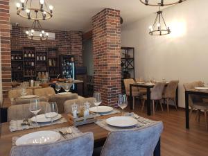 a dining room with tables and chairs and a brick wall at Peaky Hotel in Durrës