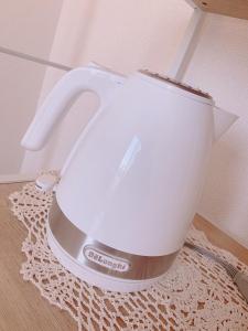 a white tea kettle sitting on top of a rug at Picoro Hakata - Vacation STAY 11331 in Fukuoka