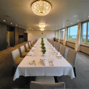 ein langes Esszimmer mit einem langen Tisch und Stühlen in der Unterkunft Guggital Hotel Restaurant in Zug