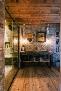 baño con pared de piedra y suelo de madera en AGRITURISMO CA' FENILE, en Alzano Lombardo