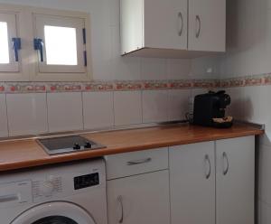 a kitchen with white cabinets and a washing machine at Inhome in Madrid