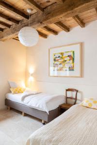 two beds in a room with wooden ceilings at Het Verblijf in Sint-Martens-Lennik