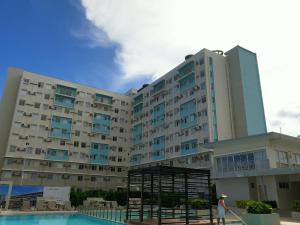 a man standing in front of a large building at Condotel DC MARINA SPATIAL FELINVEST in Dumaguete