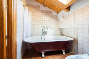a bath tub in a bathroom with white tiles at El Torreon de Navacerrada in Navacerrada