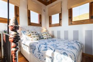a bedroom with a bed in a room with windows at El Torreon de Navacerrada in Navacerrada