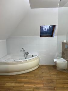 biała łazienka z wanną i toaletą w obiekcie Motel S7 w mieście Goszczyn