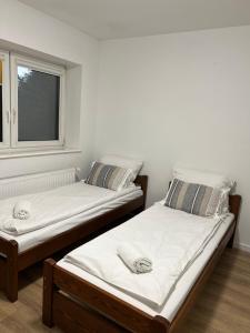 two twin beds in a room with a window at Motel S7 in Goszczyn